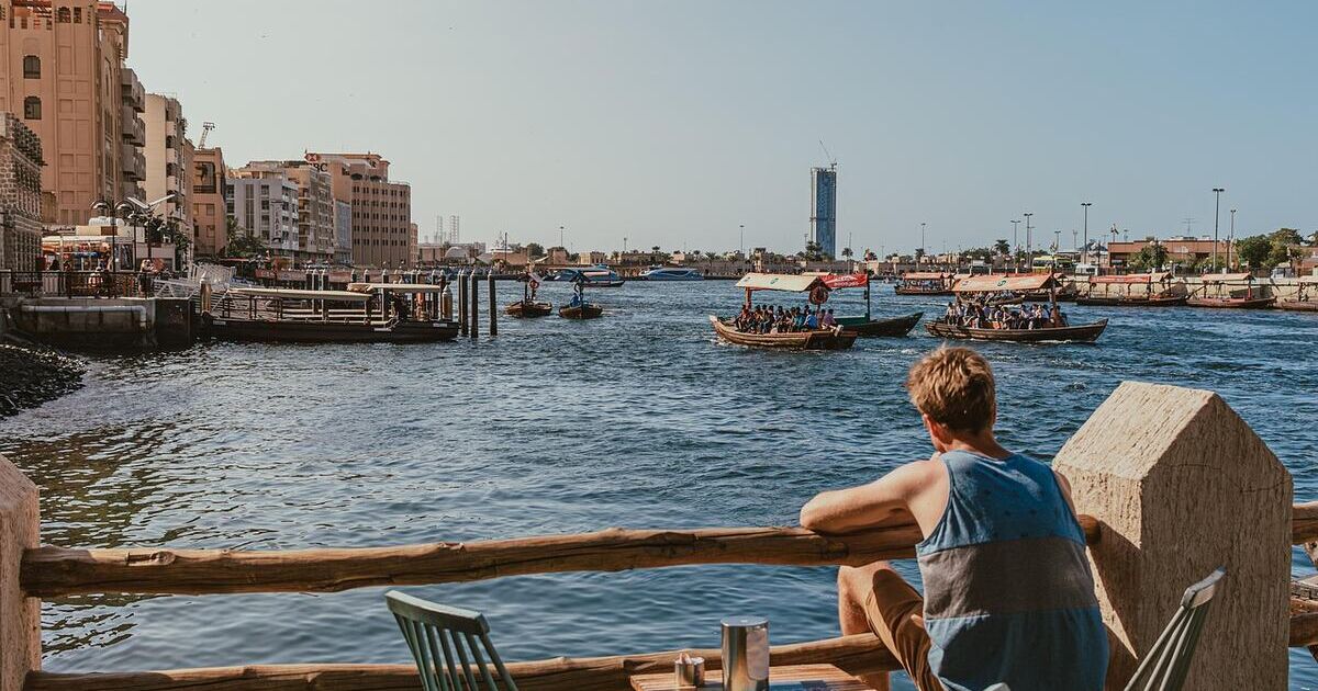A man sitting alone on a terrace by Dubai Creek
